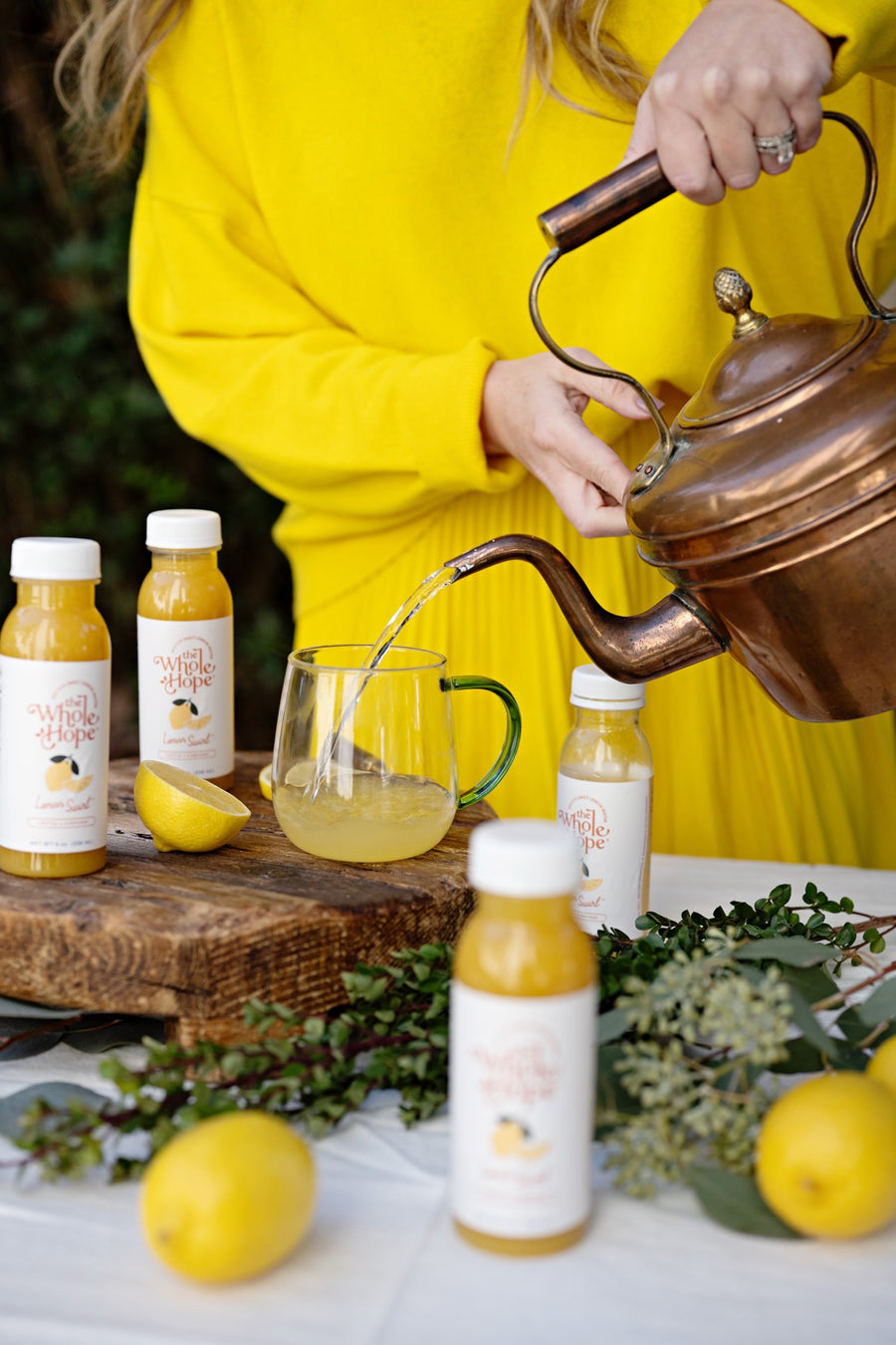 Hope pouring hot water from a copper kettle into a glass mug of Lemon Swirl
